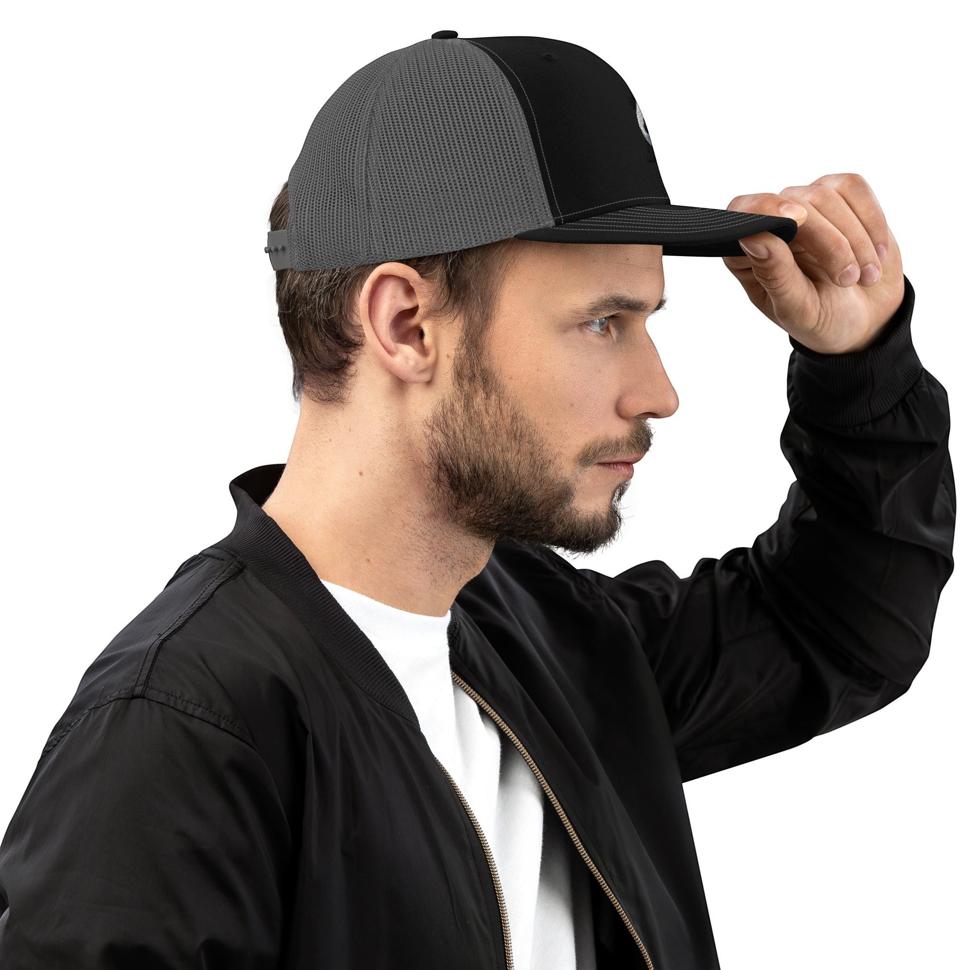 Stylio black and grey trucker cap with curved visor and mesh back, worn by a man.
