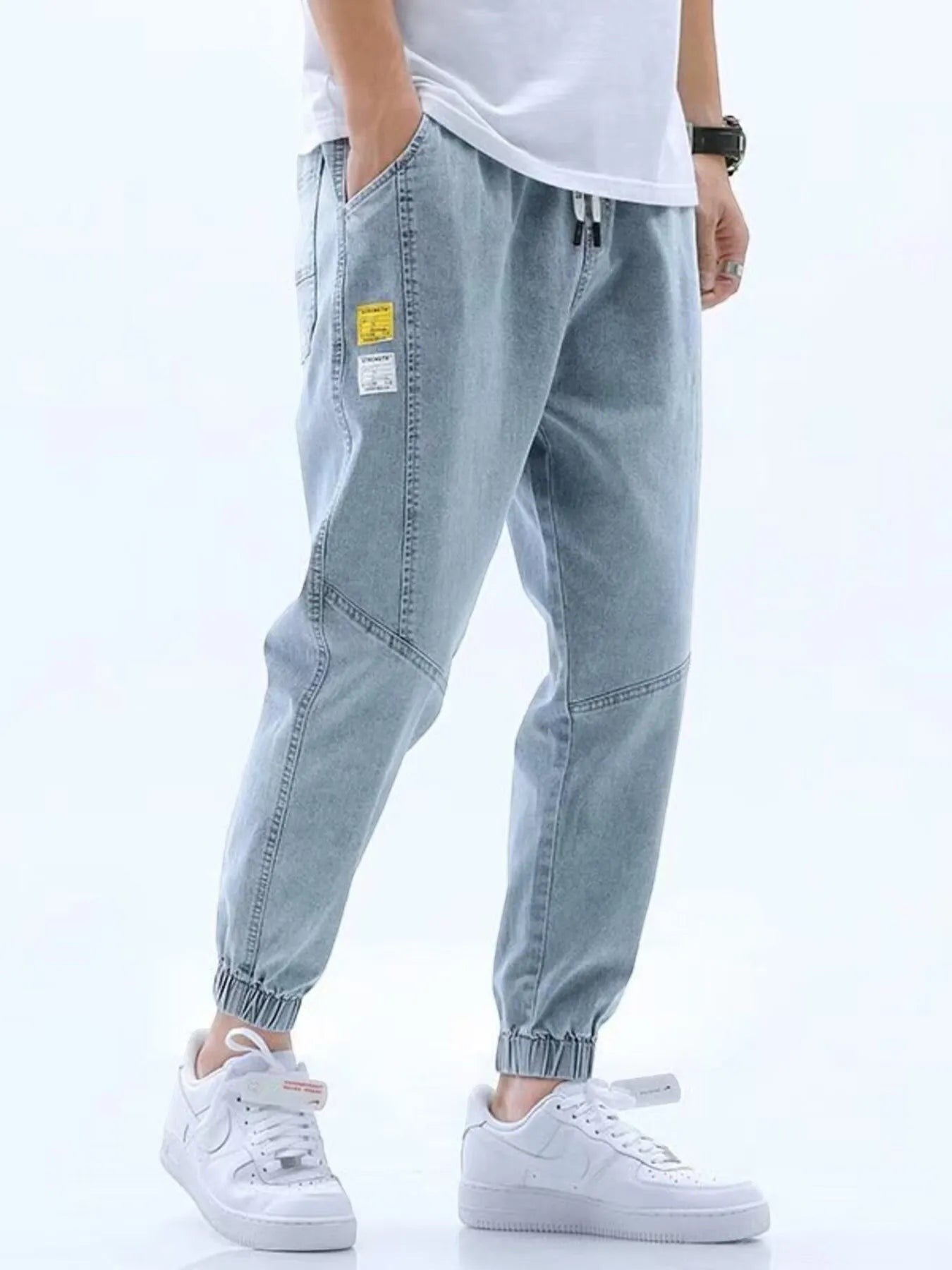 Stylio light blue wash denim jeans with drawstring waist and elastic cuffs. Relaxed fit, 100% cotton.