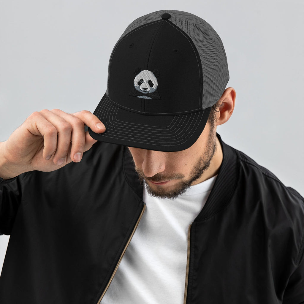 Stylio black and grey trucker cap with embroidered panda graphic. Features a structured front, curved visor, and mesh back.