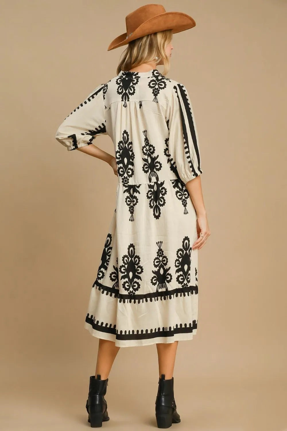 Stylio cream midi dress with black damask print, ruffled hem, and notched neckline. 90% viscose, 10% nylon.
