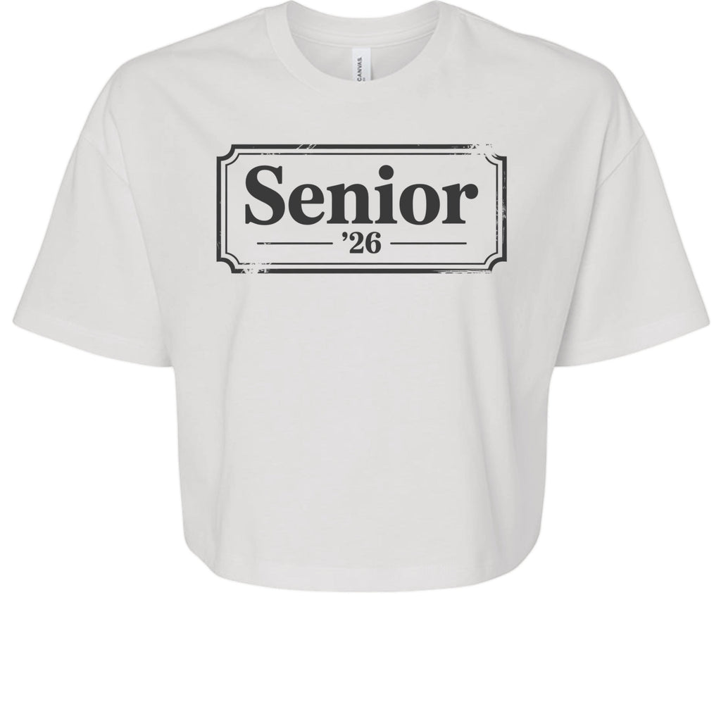 Stylio white 100% cotton crop tee with "Senior '26" graphic print. Relaxed fit, oversized sleeves, and mid-length hem.
