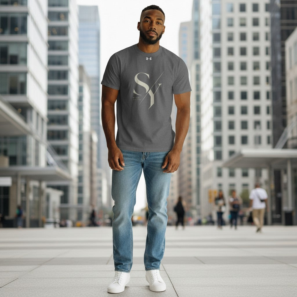 Stylio x Under Armour grey short-sleeve t-shirt with large "SY" graphic and "BE YOUR OWN STYLE" text. Made from 100% recycled polyester.