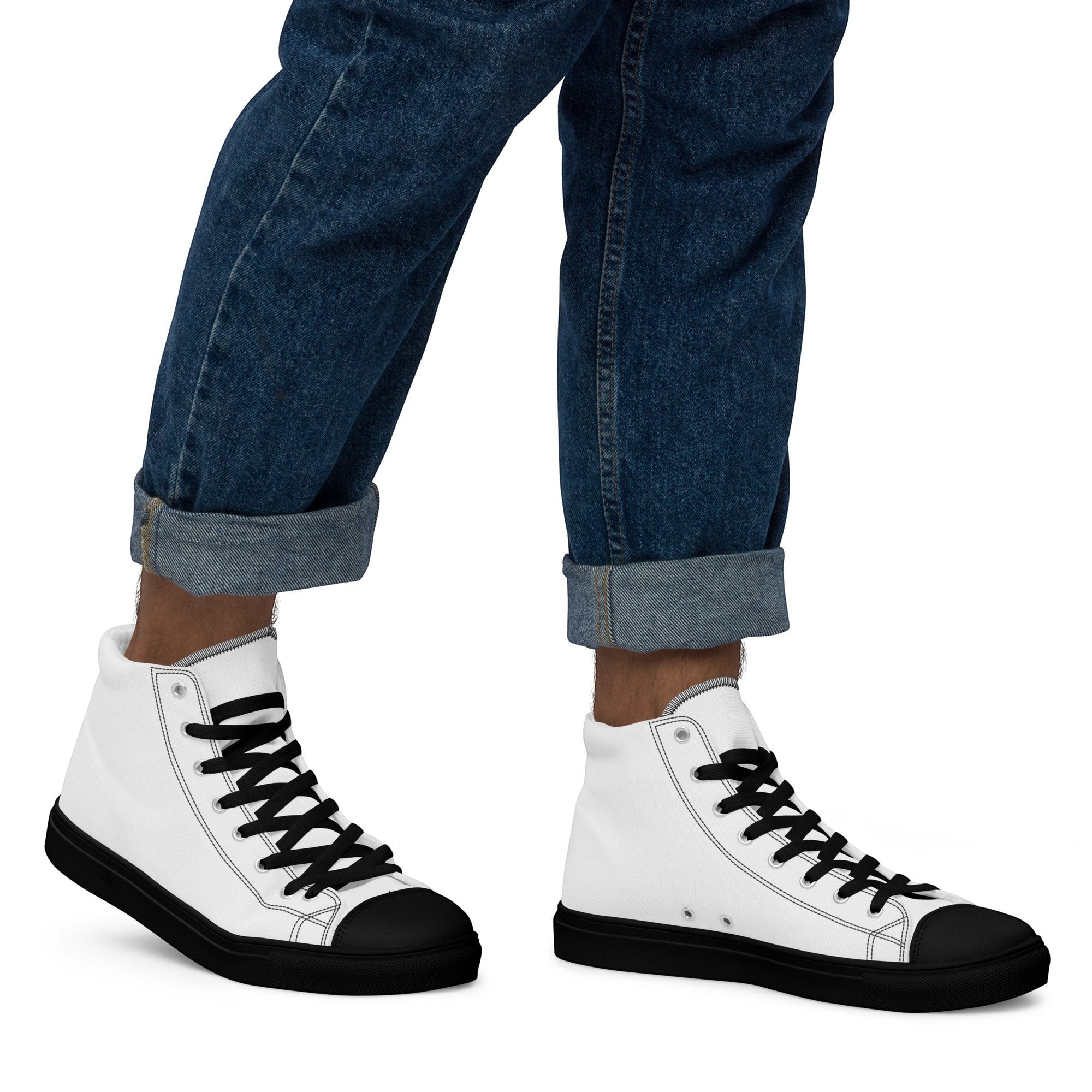 Stylio men's white canvas high top sneakers with black laces, black toe cap, and black sole. Worn with cuffed blue jeans.