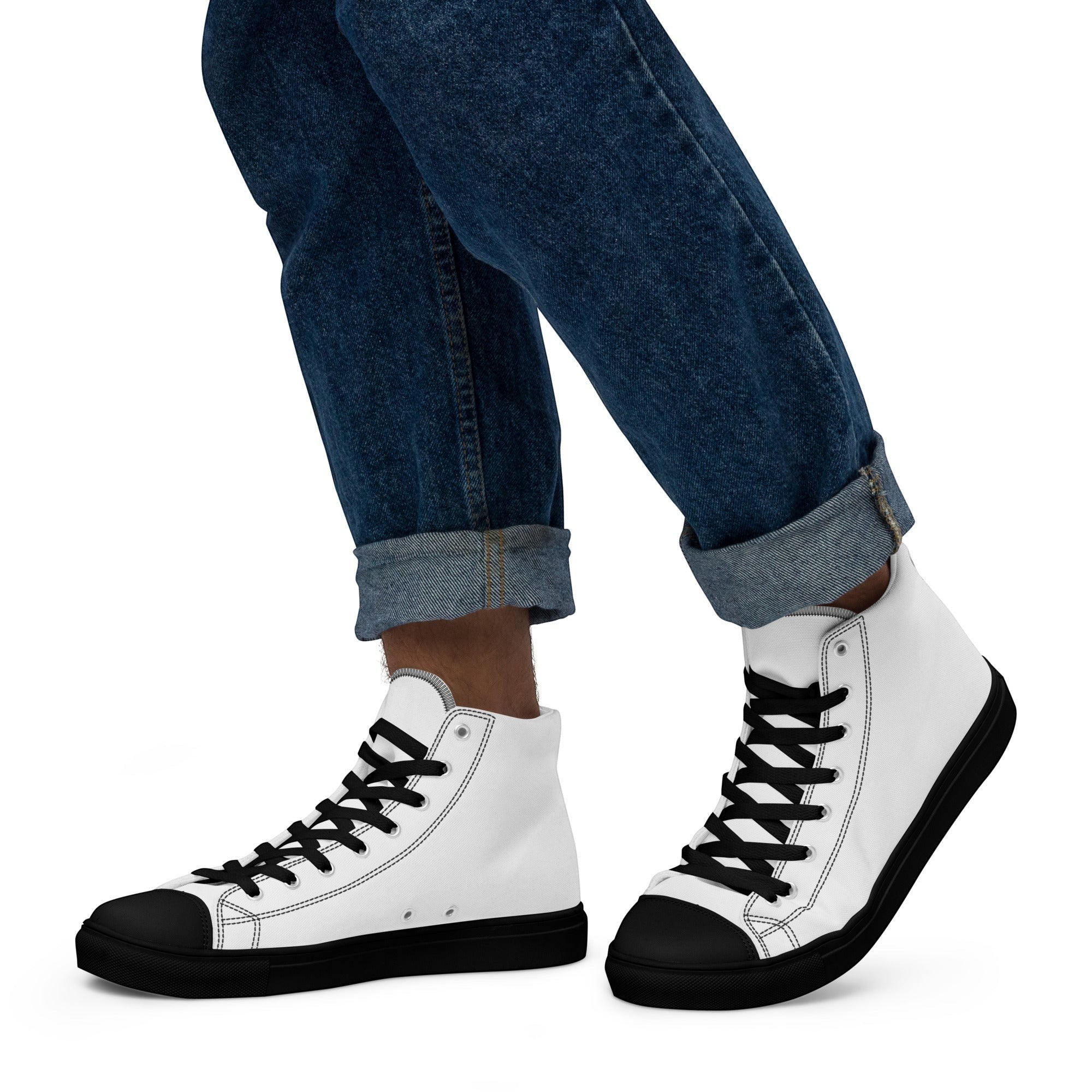 Stylio men's white canvas high-top sneakers with black laces, black sole, and black toe cap. Worn with cuffed blue jeans.