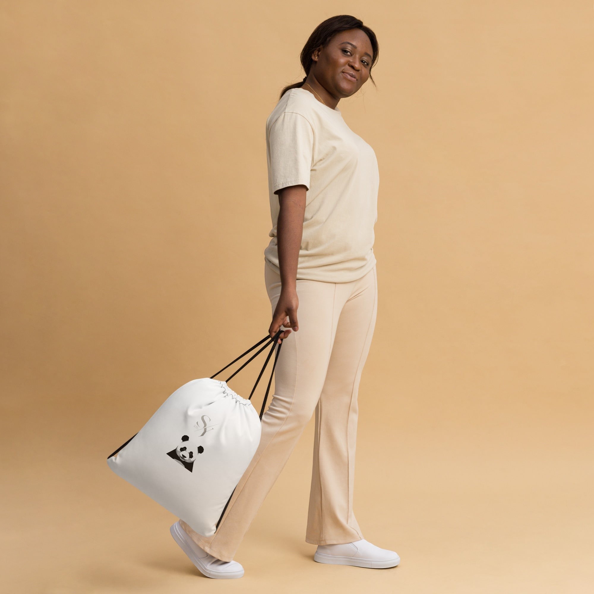 Stylio white polyester drawstring gym bag with black straps and a panda graphic, worn by a model.