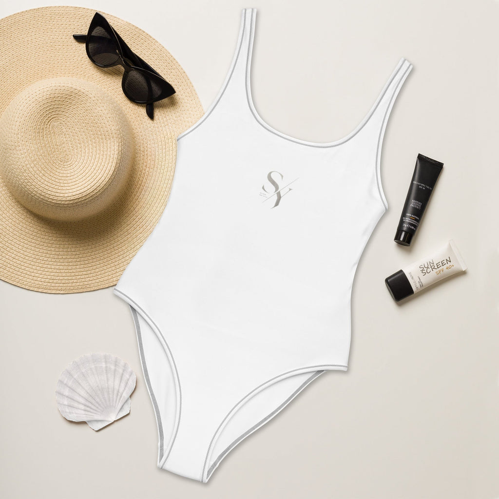 Stylio white one-piece swimsuit with scoop neckline and low scoop back, made from recycled polyester and elastane. Features grey contrast stitching.
