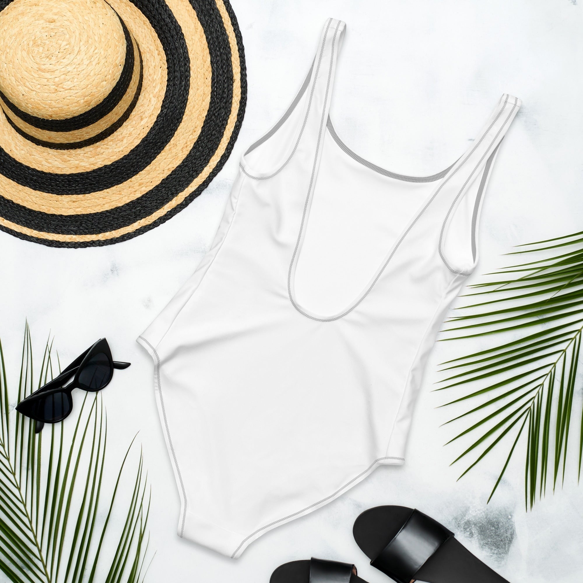 Stylio white one-piece swimsuit with scoop neckline and low scoop back, made from recycled polyester and elastane. Features cheeky fit and zig-zag stitching.