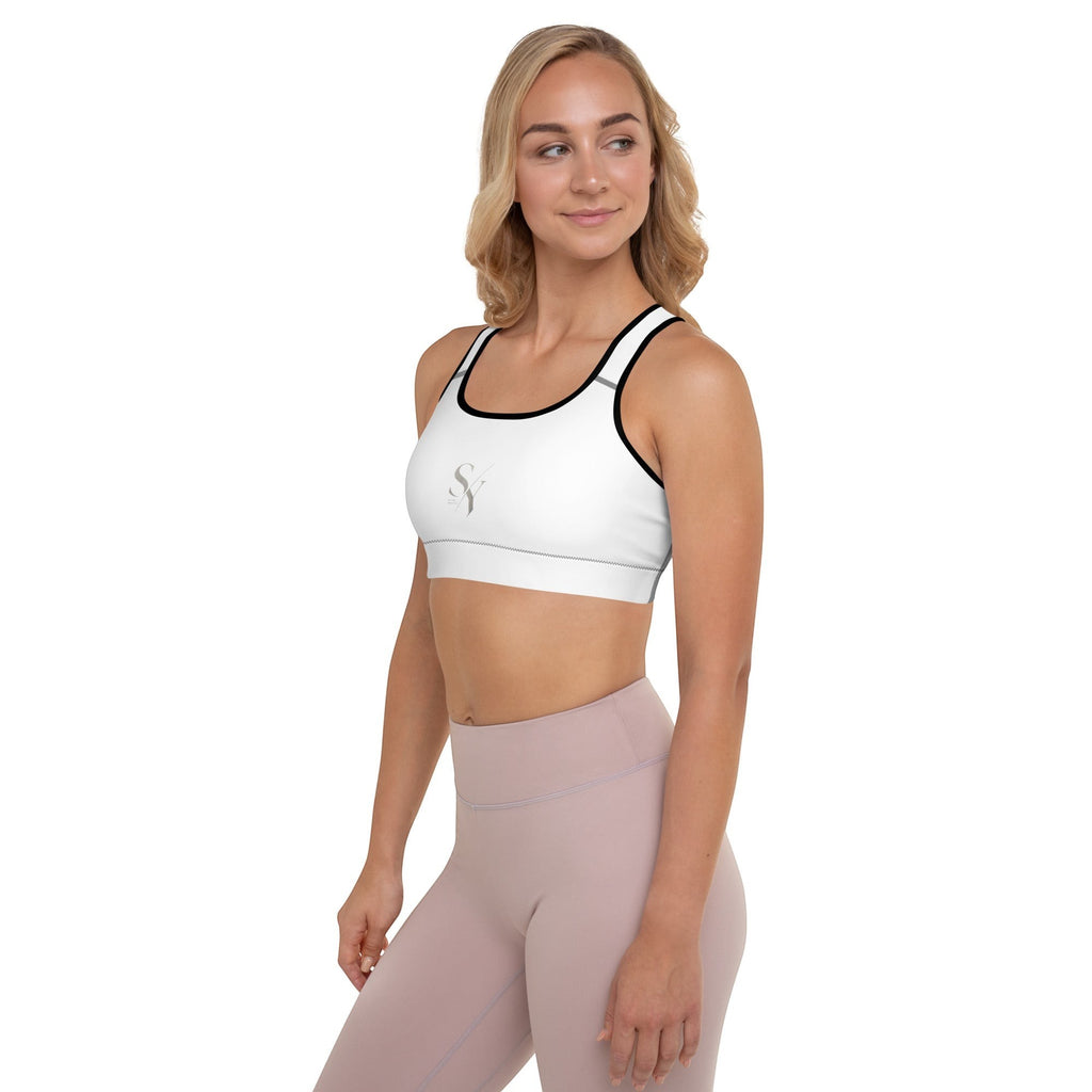 Stylio white padded sports bra with black trim, scoop neckline, and racerback. Moisture-wicking fabric and removable padding for support.