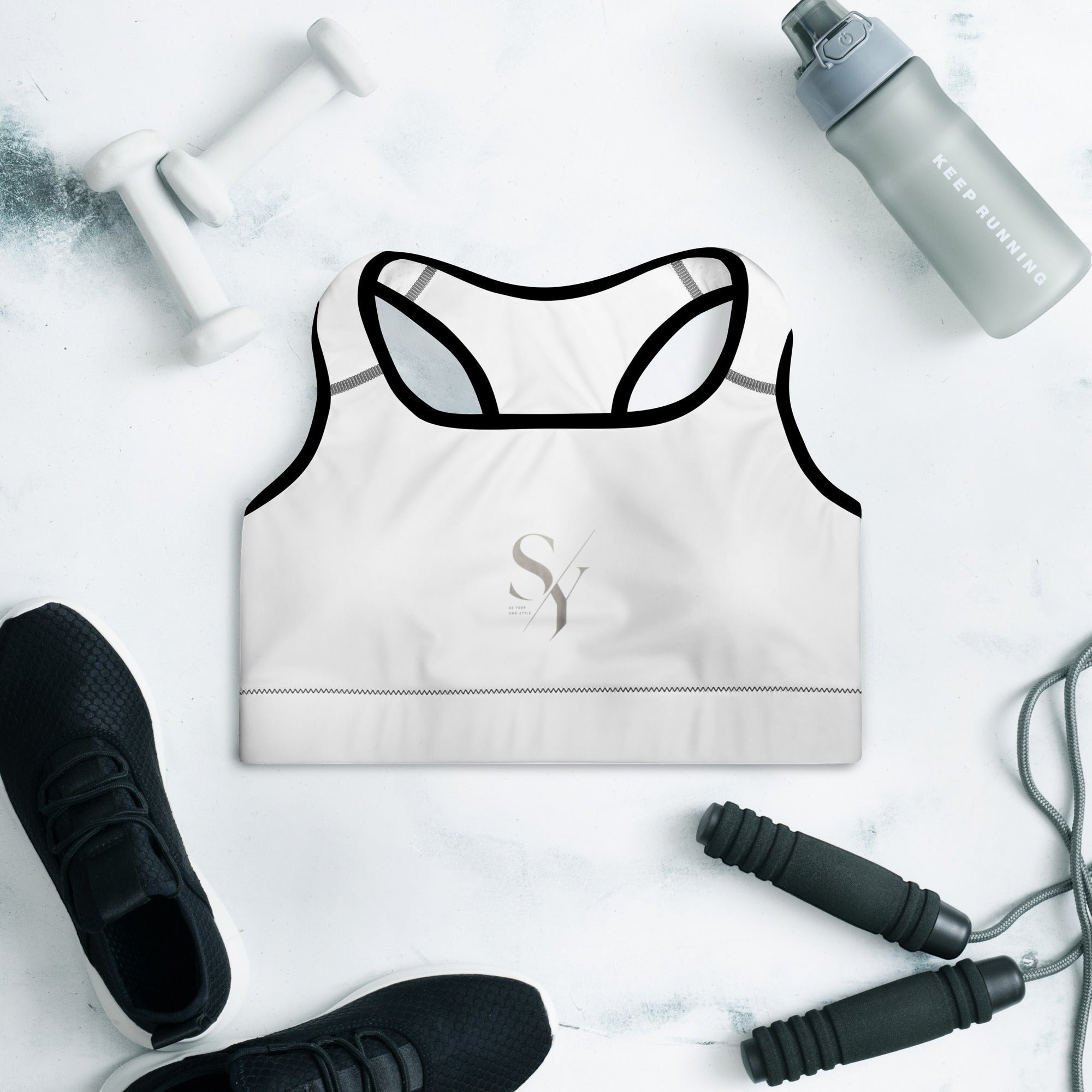 Stylio white padded sports bra with black trim, scoop neckline, and racerback. Features removable padding and moisture-wicking fabric for maximum support.