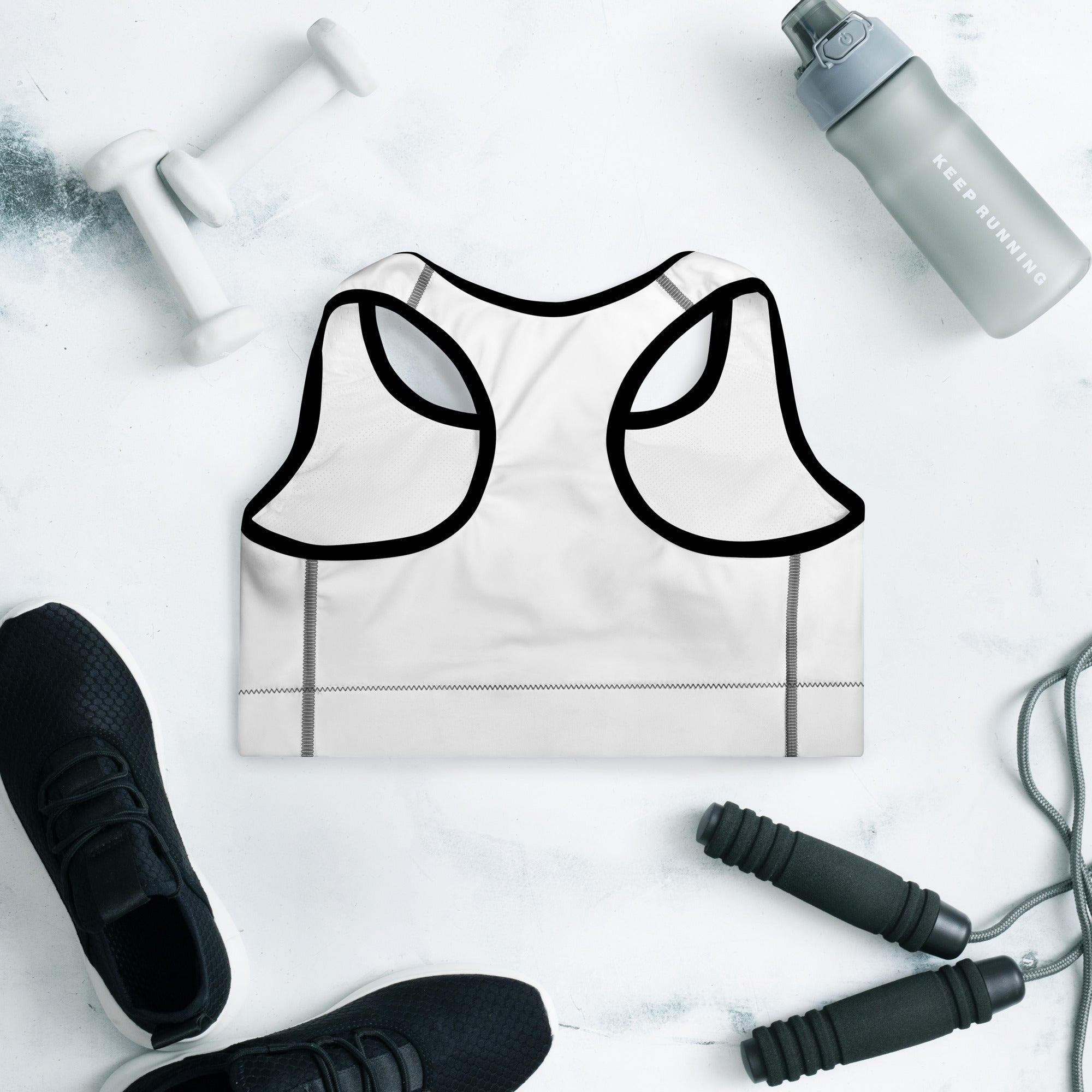 Stylio white padded sports bra with black trim, scoop neckline, and racerback. Moisture-wicking fabric, removable padding.
