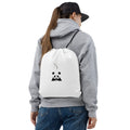 Stylio white polyester drawstring bag with a black panda graphic and logo, worn by a person with a grey hoodie and jeans.